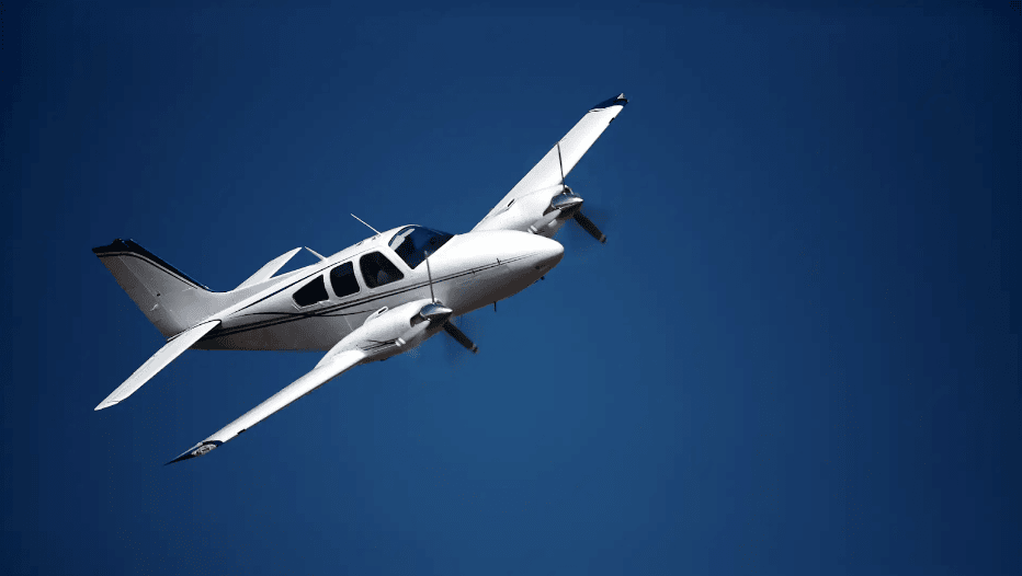 Aircraft Liability Insurance – Small white plane in the air, with a dark blue sky.